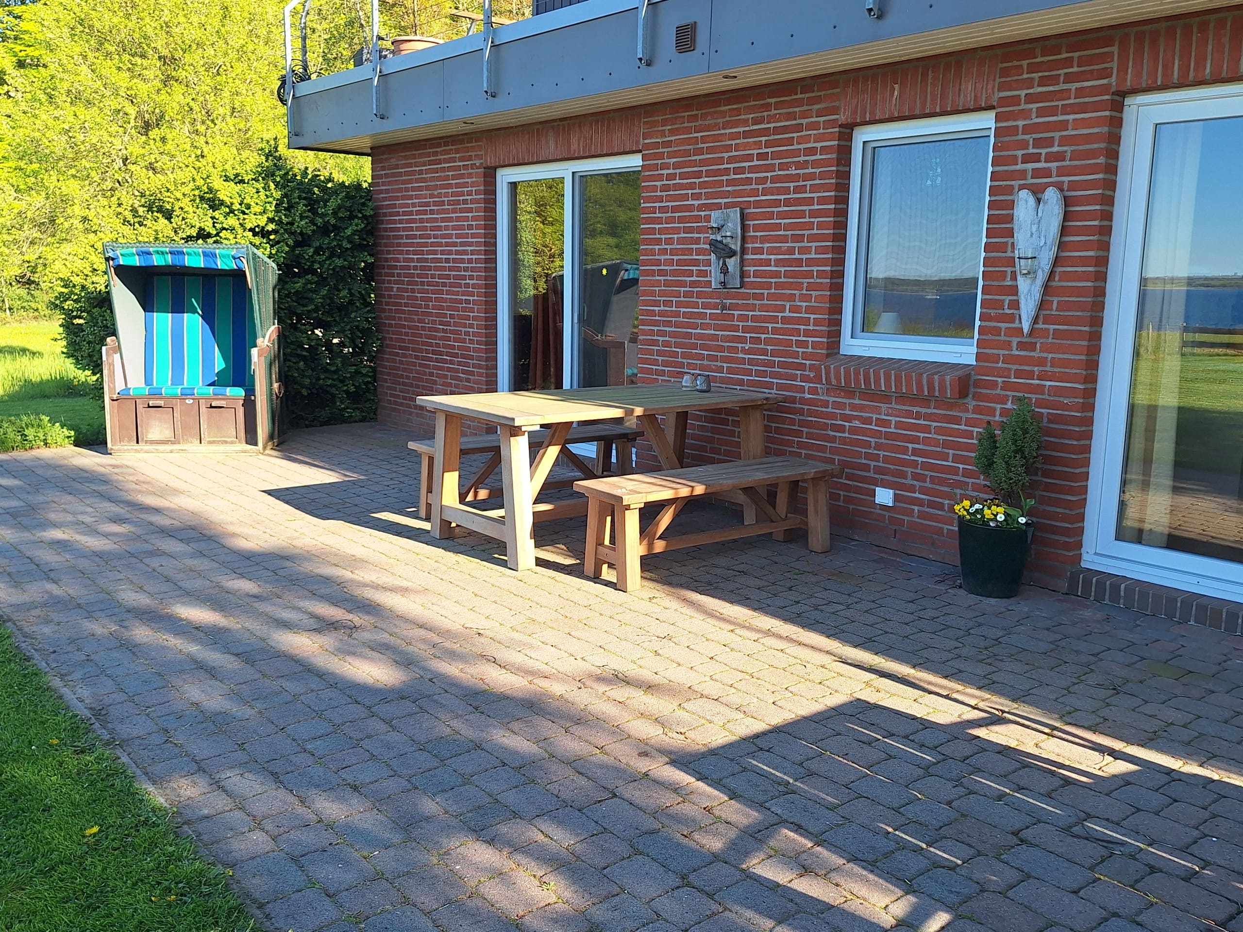 Terrasse mit Strandkorb und Tisch mit Bänken