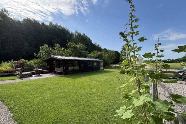 Großes Gartenhaus mit Sitzgelegenheit davor in großzügigem, gepflegten Bauerngarten